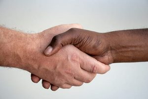 Valko- ja mustaihoiset kädet yhteen rasismia vastaan