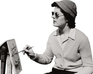 Nainen, jolla on aurinkolasti ja hattu, maalaa pienelle taululle