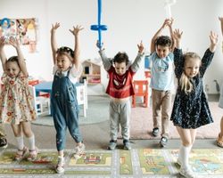 5 lasta pitävät kädet ylhäällä päiväkodin leikissä