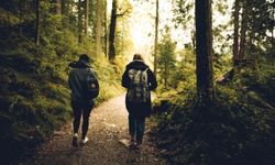 Kaksi naista kävelevät metsässä reput selässä