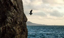 Ihminen hyppää korkealta kalliolta veteen