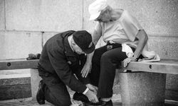 Vanhempi mies auttaa vaimoaaan solmimaan kengännauhat