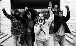 5 nuorta aktivistia protestoimassa megafonin avulla 