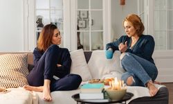2 naista vaihtavat ajatuksiaan sohvalla kahvikupin kanssa