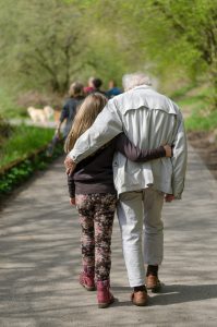 Vanha mies ja nuori lapsi kävelevät yhdessä pitäen toisistaan kiinni