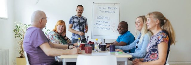 Iloinen joukko neuvottelypöydän ääressä